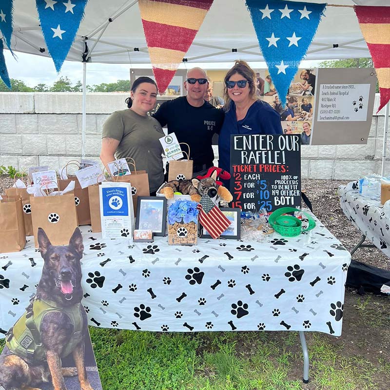 people gathered together below a patriotic banner and behind table with a paw-print-pattern tablecloth