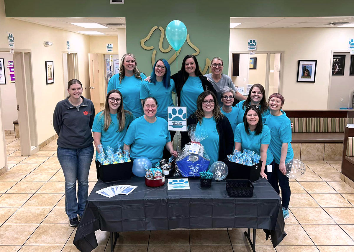 Encore team members wearing all blue standing behind a table at an event