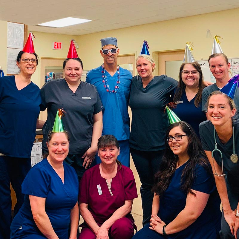 Encore team standing as a group and wearing party hats